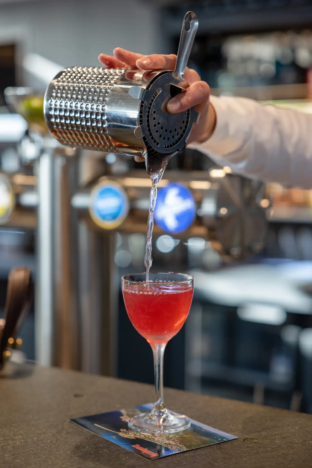 Ein Barkeeper gibt einen roten Drink in der 1893 Bar auf MS Finnmarken in ein Glas ein