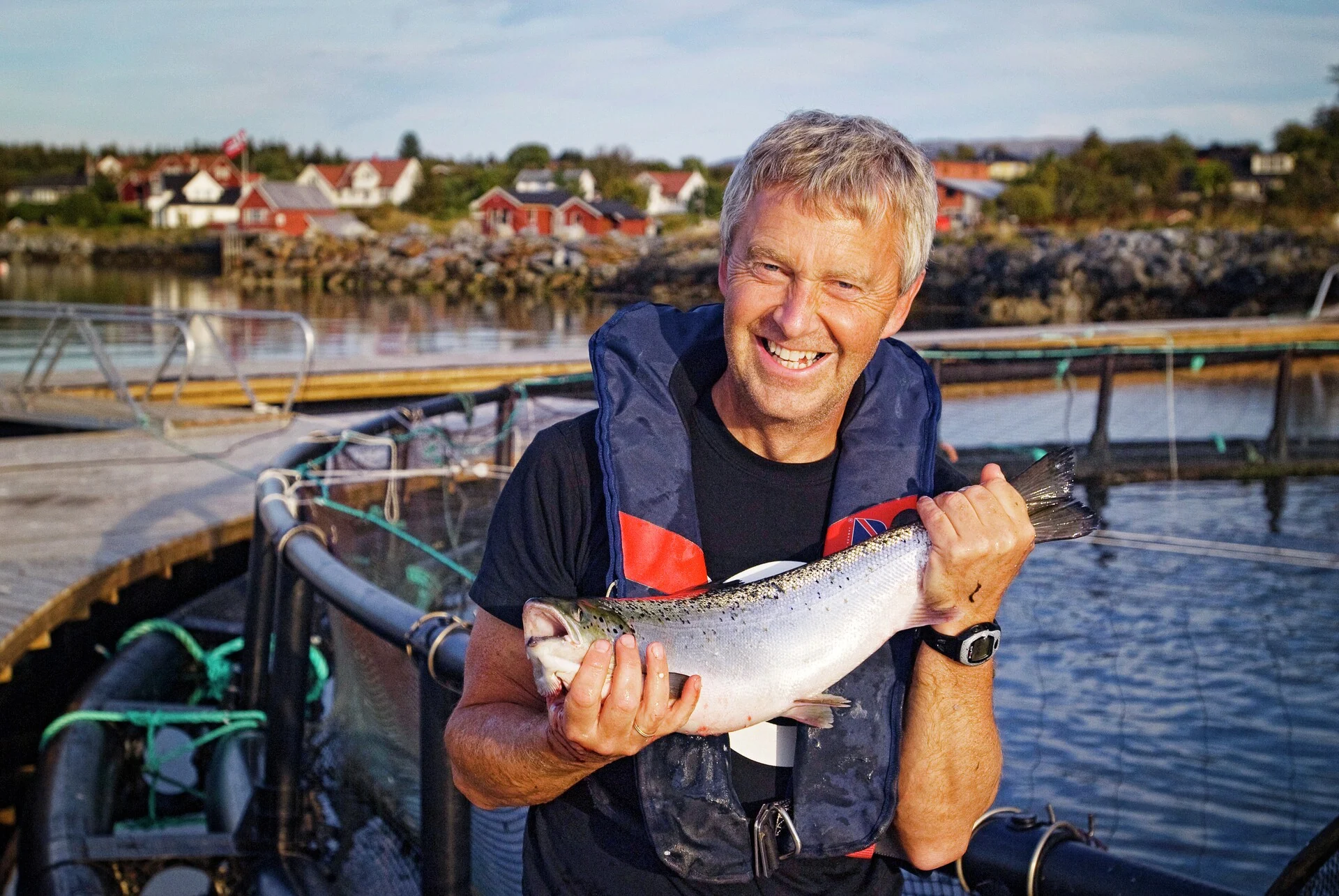 Un homme tient un saumon qu'il vient d'attraper lors d'une sortie de pêche.