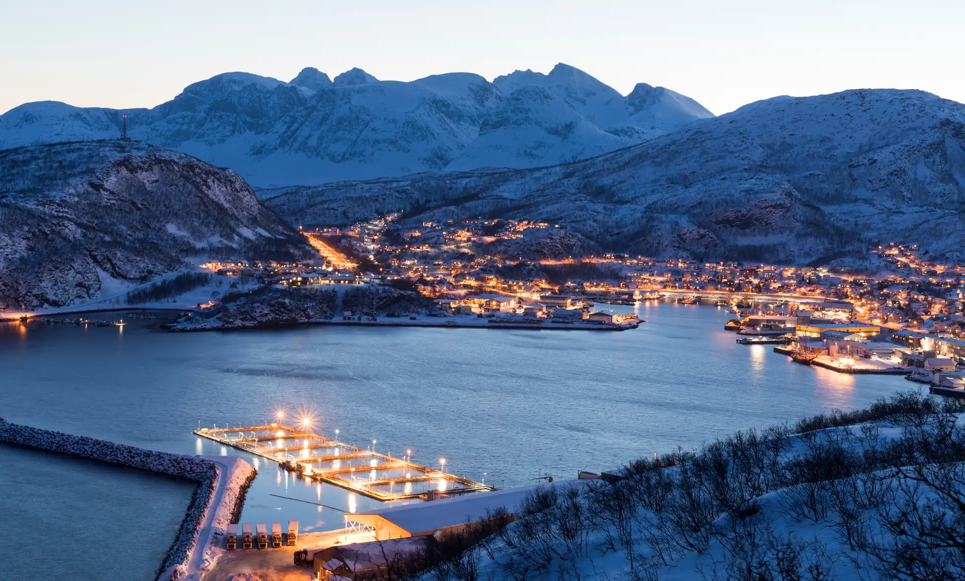 A view over Skjervøy, Norway in the evening, surrounded by snowy mountains