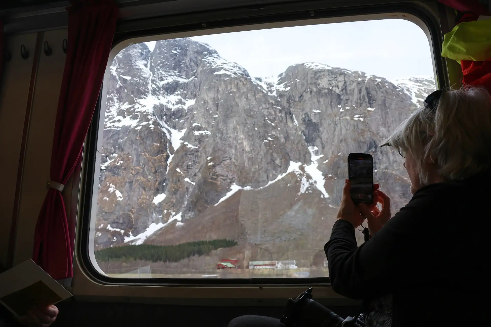 golden-train-passenger-photographing-snowcapped-romsdal-alps-andalsnes-mobile-device