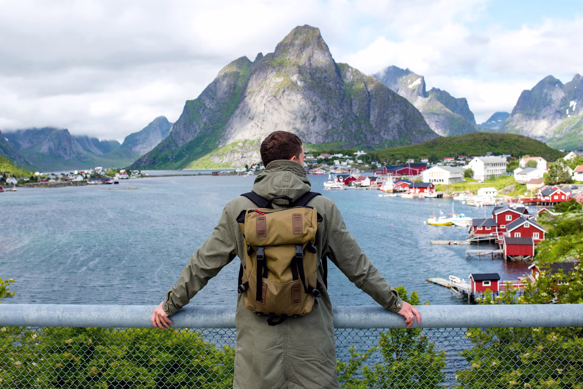 Backpacker enjoying scenic Reine harbor and Lofoten Islands in northern Norway