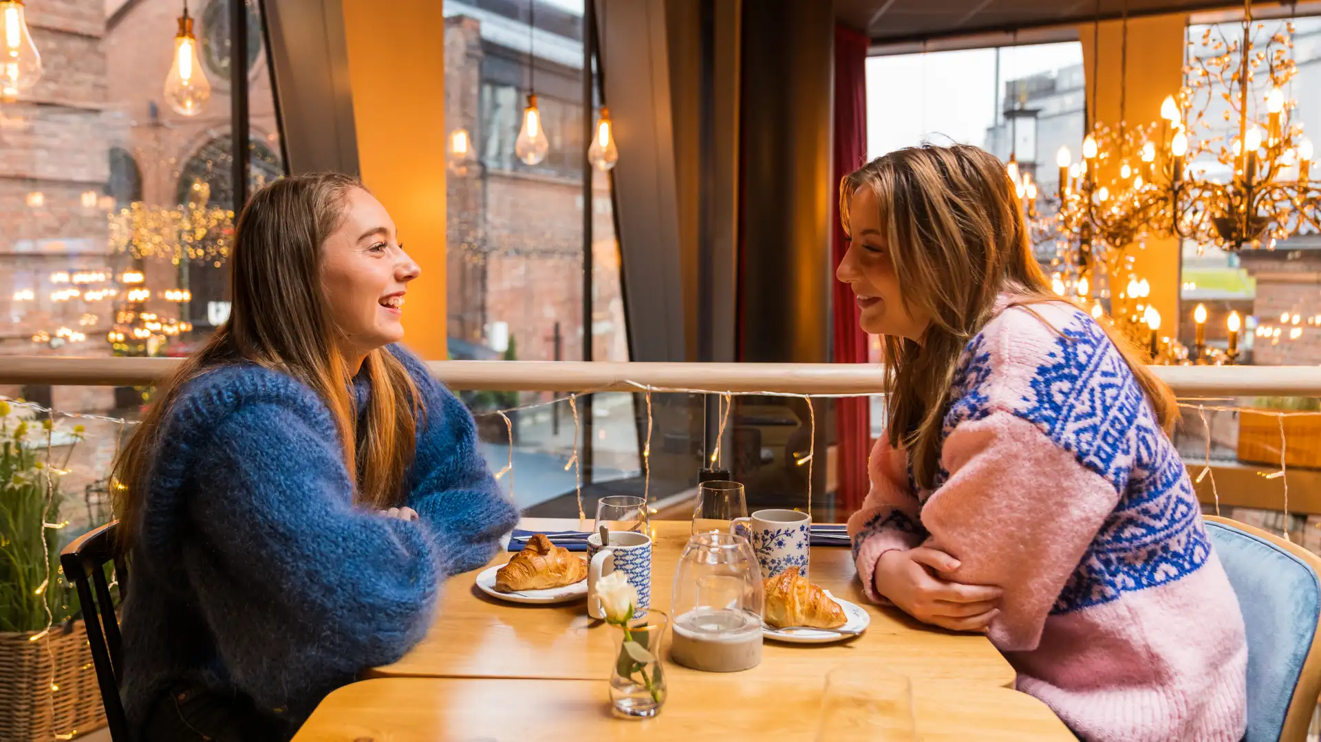 Two friends in a café in Norway with drinks and pastries. Image copyright: Fredrik Ahlsen - Visit Norway