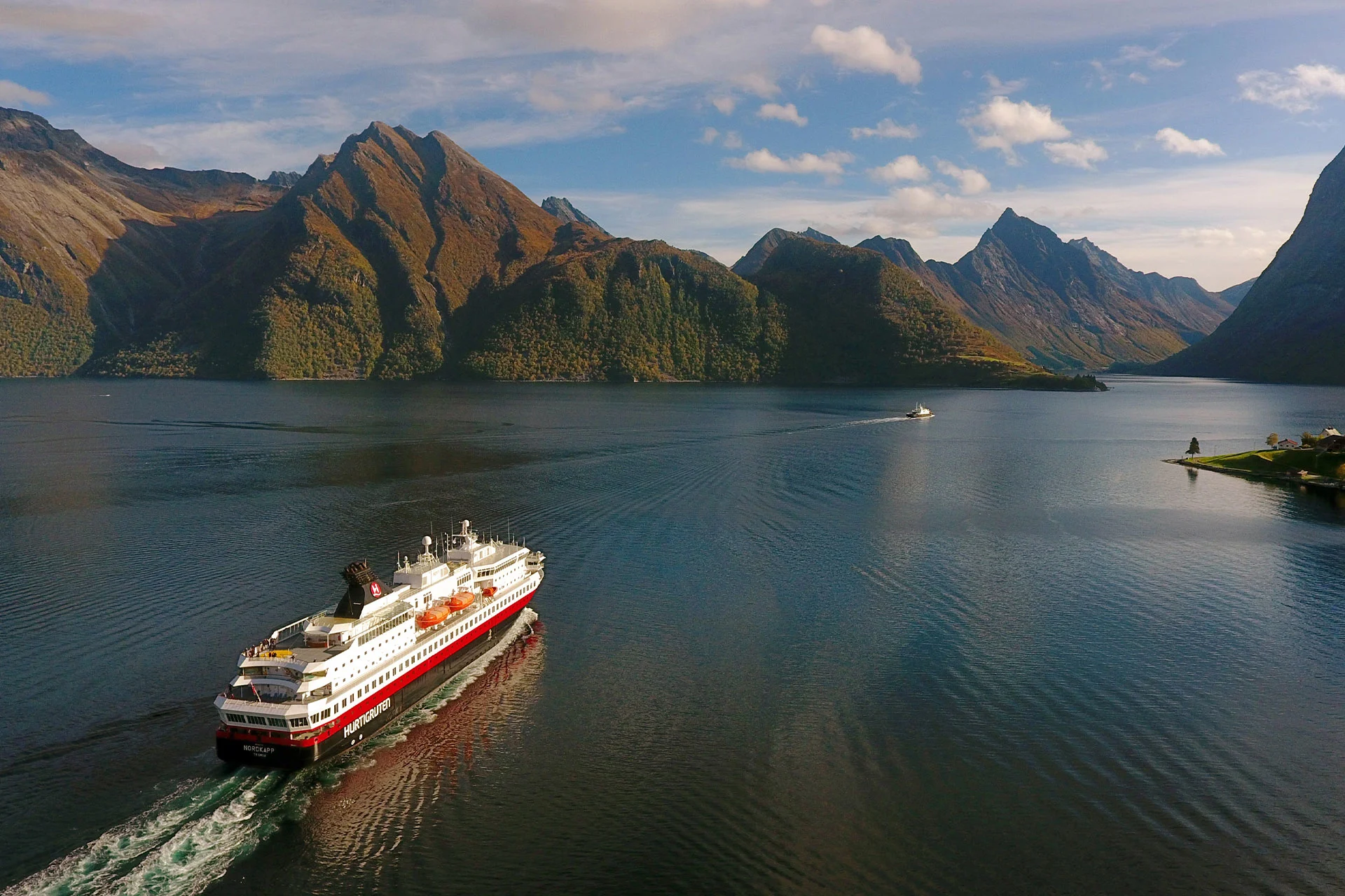 Un navire Hurtigruten naviguant dans le Hjørundfjord en automne