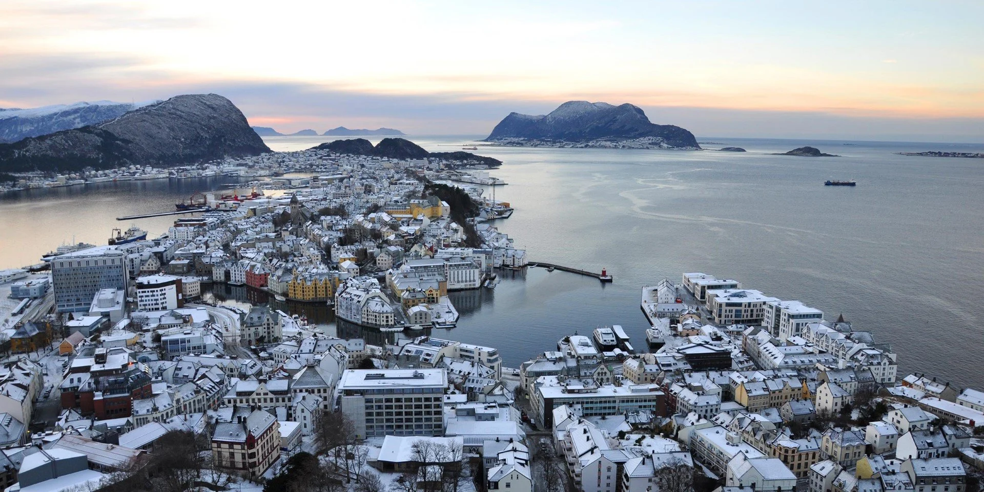 A large body of water with buildings in the snow