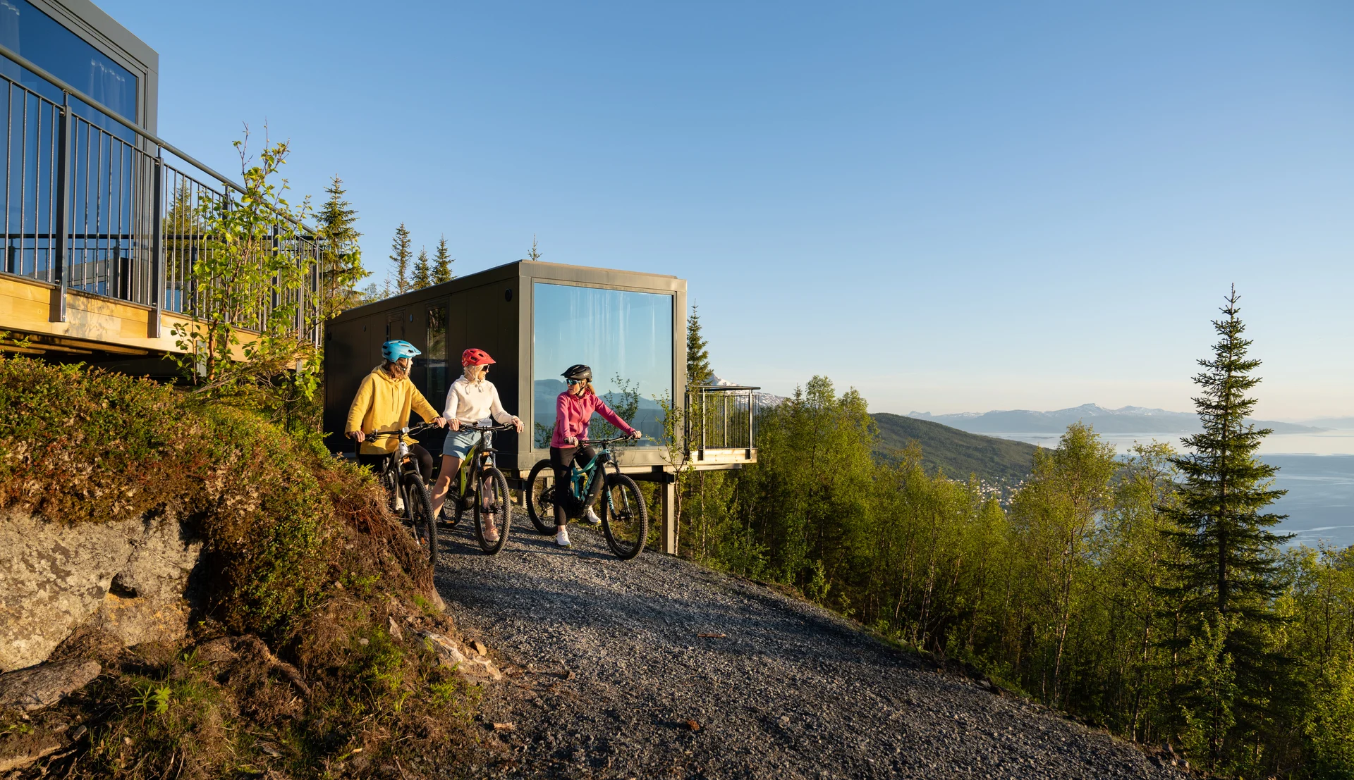 A group of women mountain biking on Narvikfjellet beneath the Midnight Sun. Image credit: Narvikfjellet