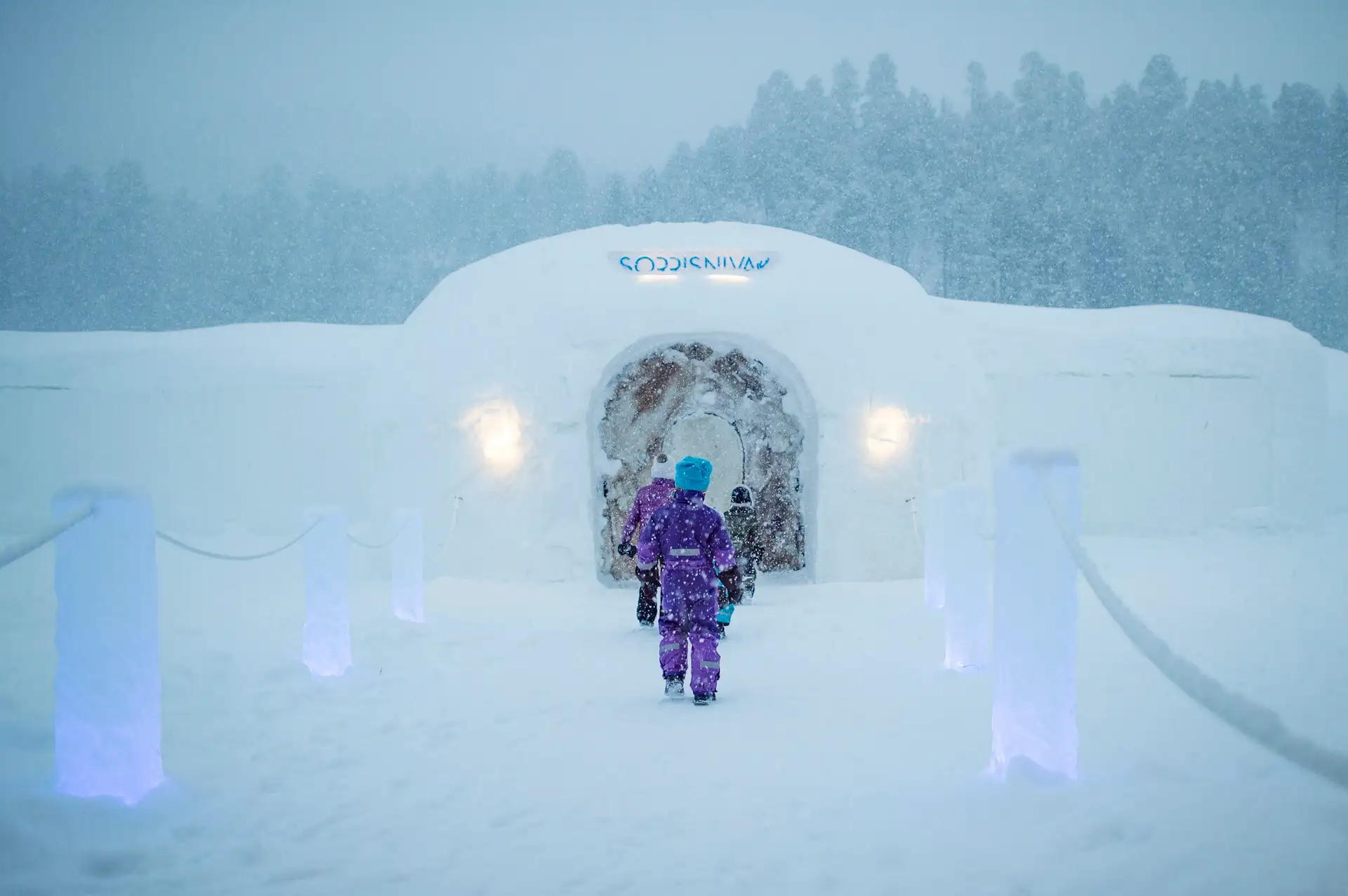 people-walking-into-sorrisniva-igloo-hotel