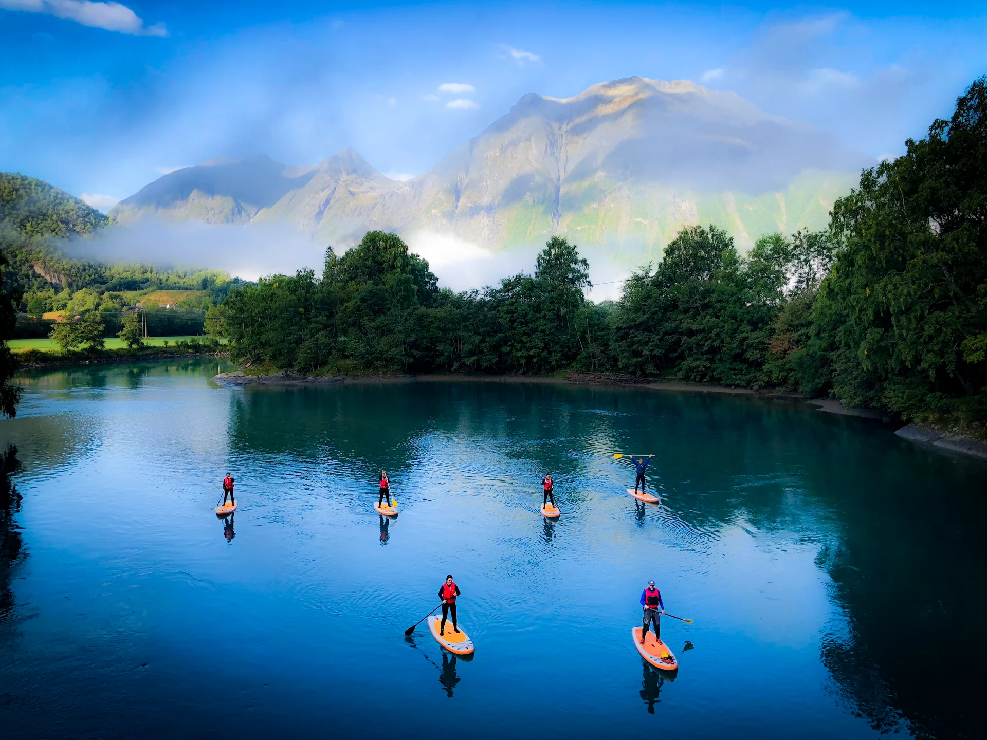 A group of stand-up paddleboarders (SUP) explore the Rauma and Istra rivers in Åndalsnes. Image copyright: Tindesenteret - Visitnorthwest.no