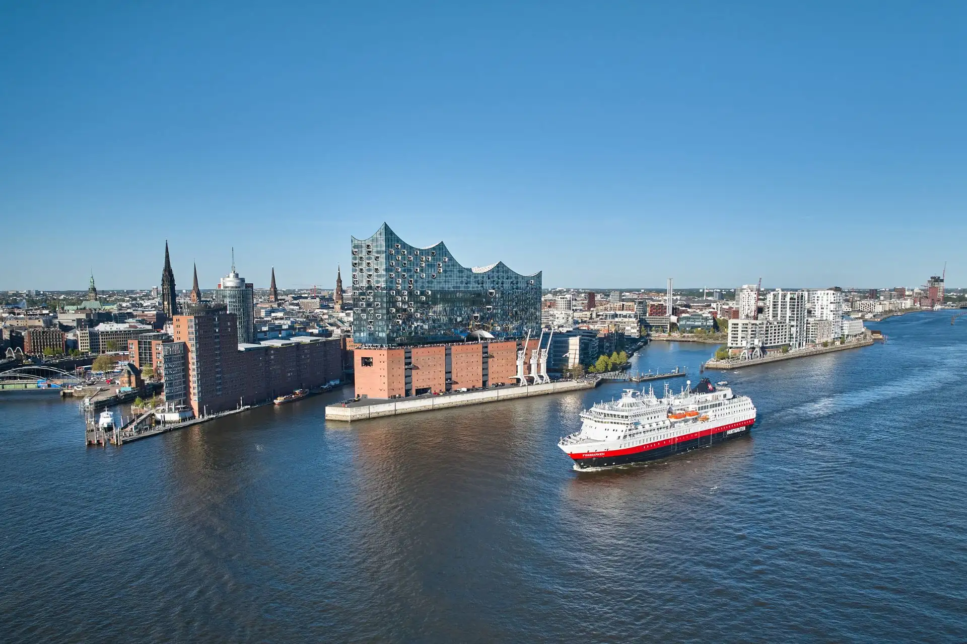 MS Finnmarken fährt auf der Elbe durch den Hamburger Hafen. Im Hintergrund ist die Elbphilharmonie zu sehen. © AUSSENBORDER Hurtigruten