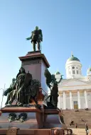 A group of people sitting on a bench in front of a building