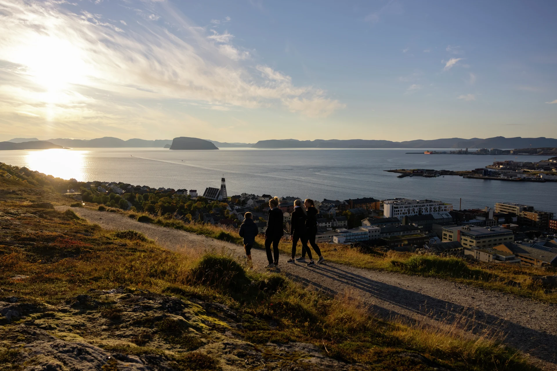 Un groupe de randonneurs marchant à Hammerfest au coucher du soleil