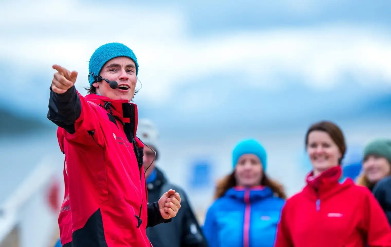 Hurtigruten Expedition Team member talking to passengers on deck