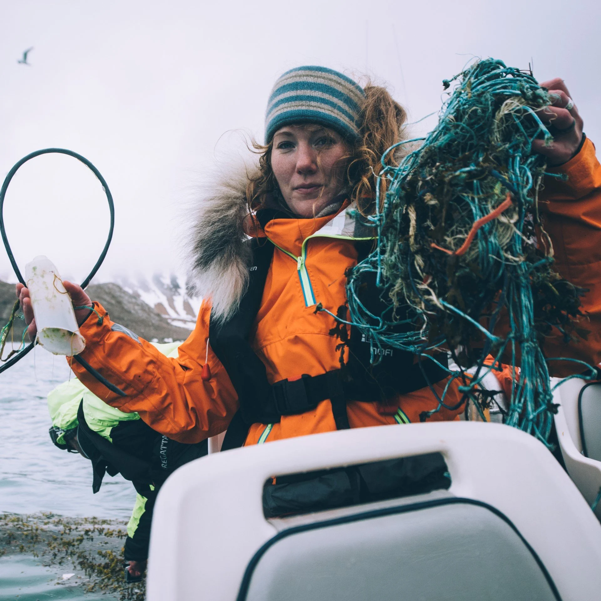 Helga on a small speedboat pulling plastic from the ocean