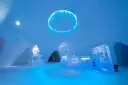 Inside the Kirkenes Snowhotel. A frozen blue chandelier, an ice front desk and snow walls