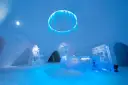 Inside the Kirkenes Snowhotel. A frozen blue chandelier, an ice front desk and snow walls