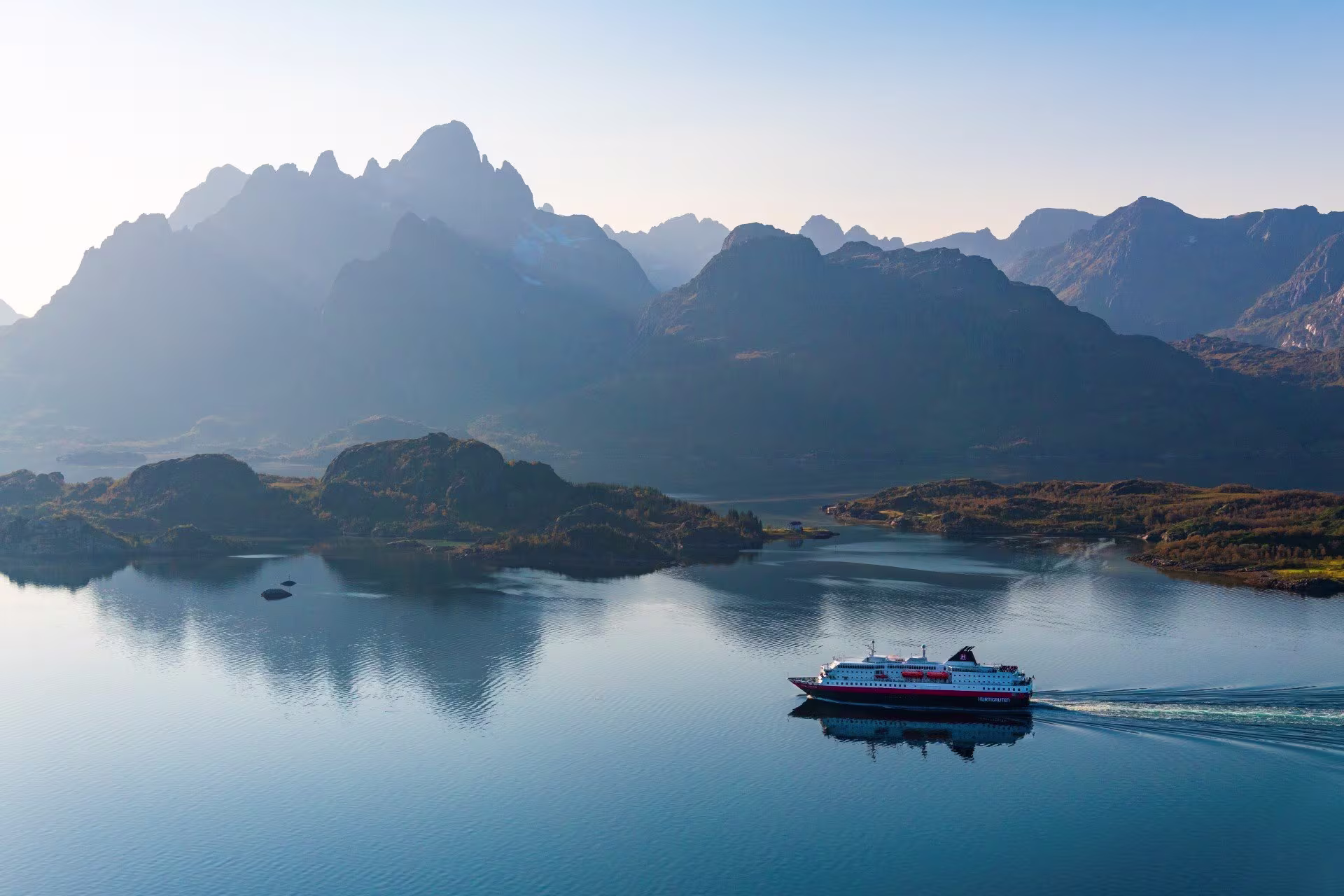 Hurtigruten Schiff im Raftsund, Norwegen. Das Wasser ist ruhig und der Himmel ist blau