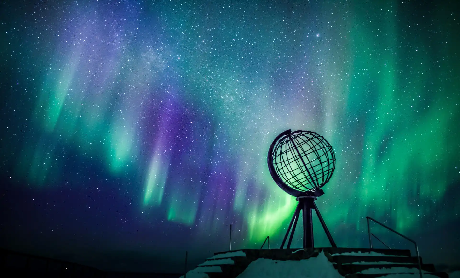 The globe statue on The North Cape surrounded by northern lights