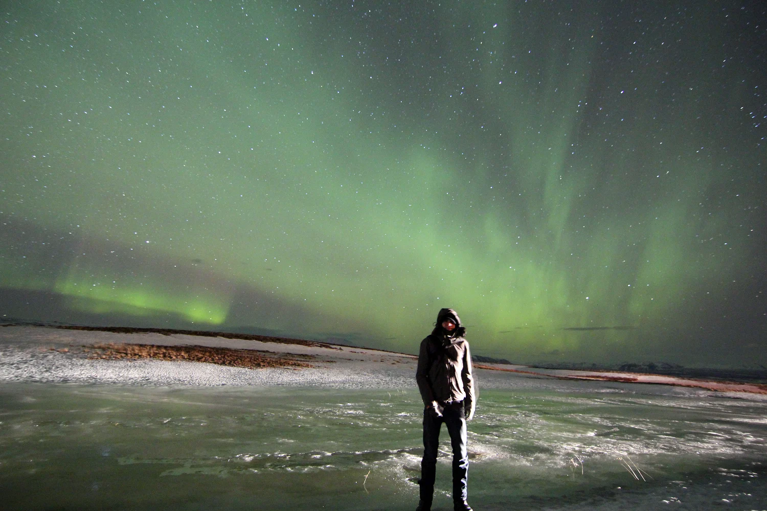 Astronomer Tom Kerss standing underneath the Northern Lights in Norway