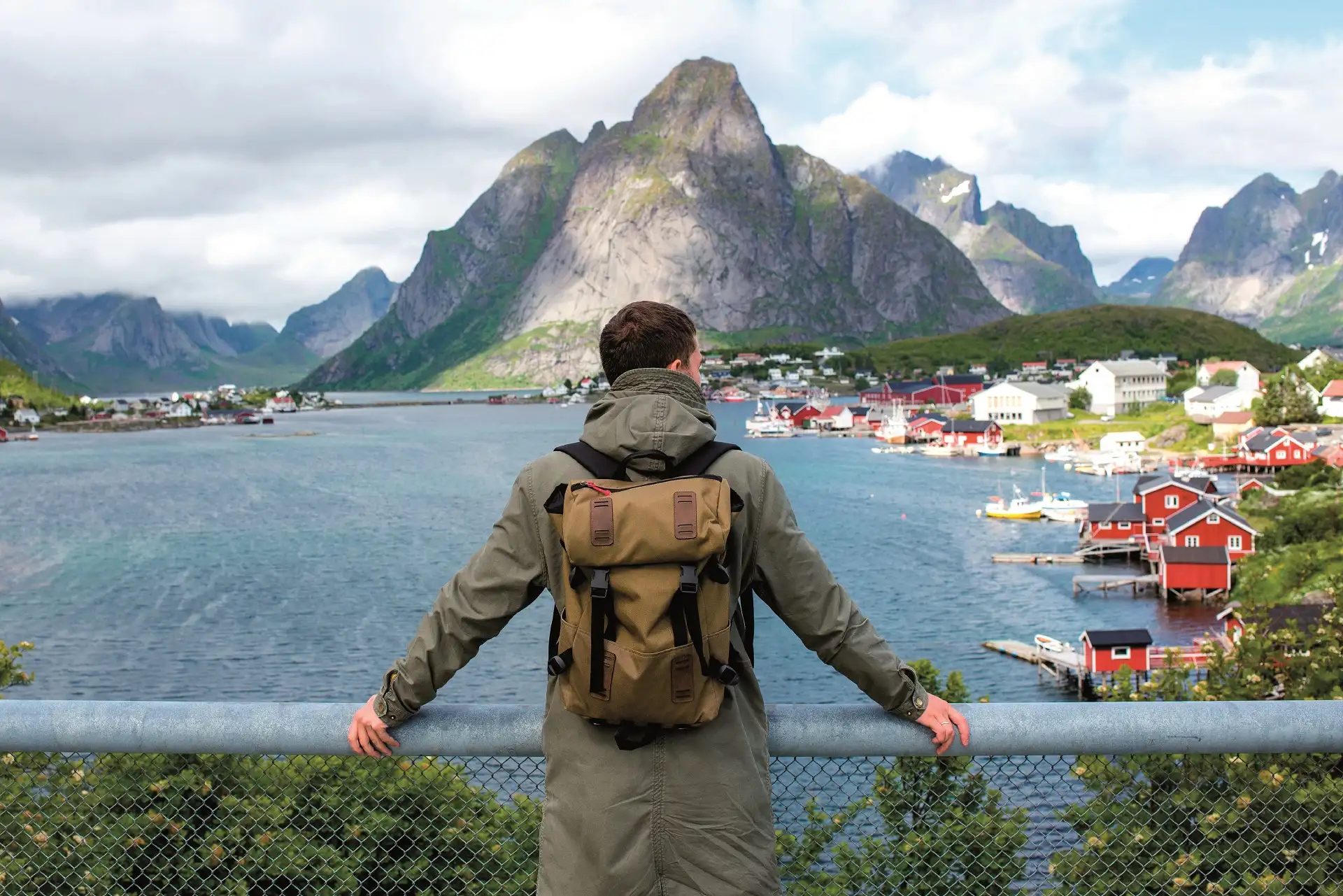 A hiker overlooking villages in Lofoten, Norway