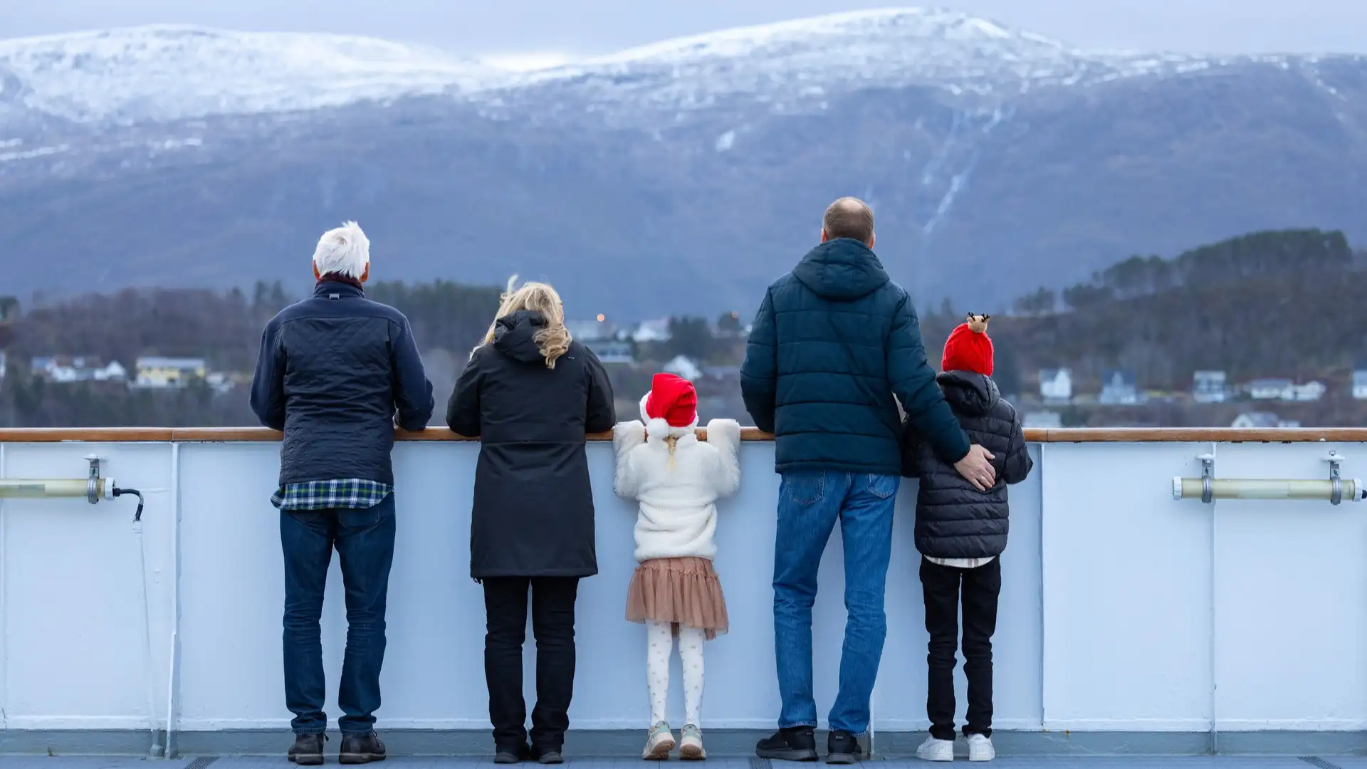A family standing on the deck of a Hurtigruten ship at Christmas