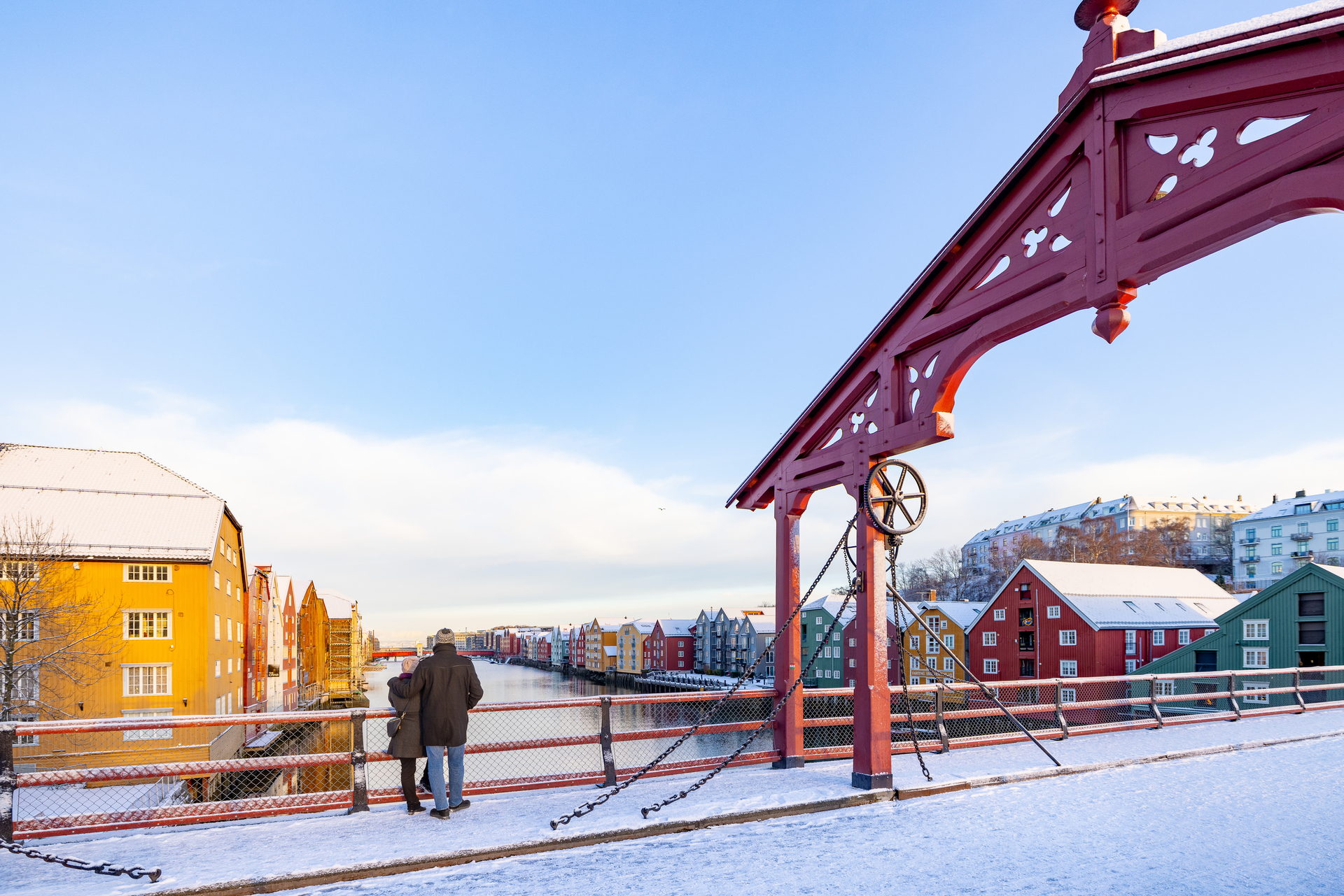 A couple in Trondheim on the snow-covered Heart Bridge looking over the River Nid