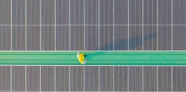 A bird's eye view of a worker surrounded by solar panels