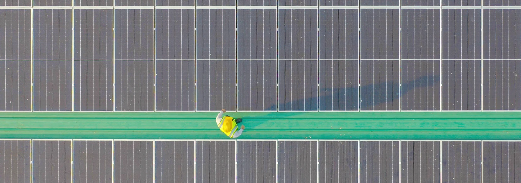 A bird's eye view of a worker surrounded by solar panels