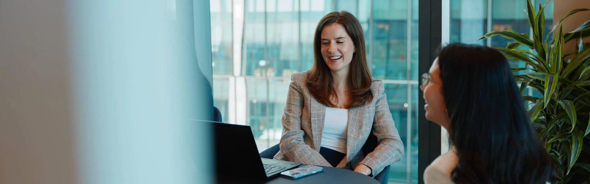 Two women sitting at a table with a laptop