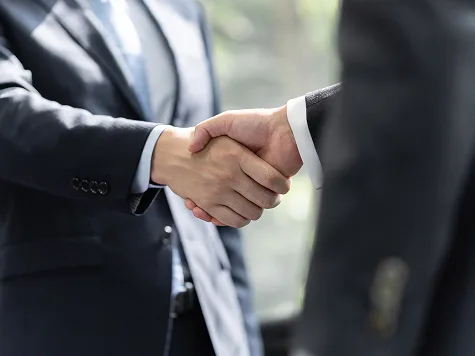 Two men in suits shaking hands