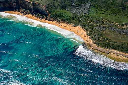 Aerial Photograph showing the ocean meeting the shore.