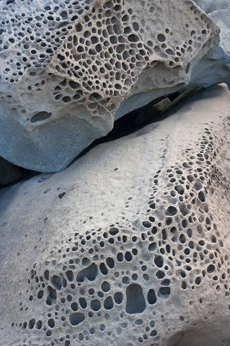 Photograph of rock formation with honeycomb like surface.