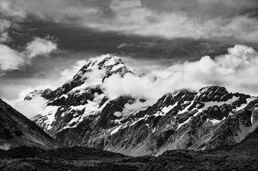 Photograph of a snow capped Aoraki/Mount Cook partly shrouded in cloud.