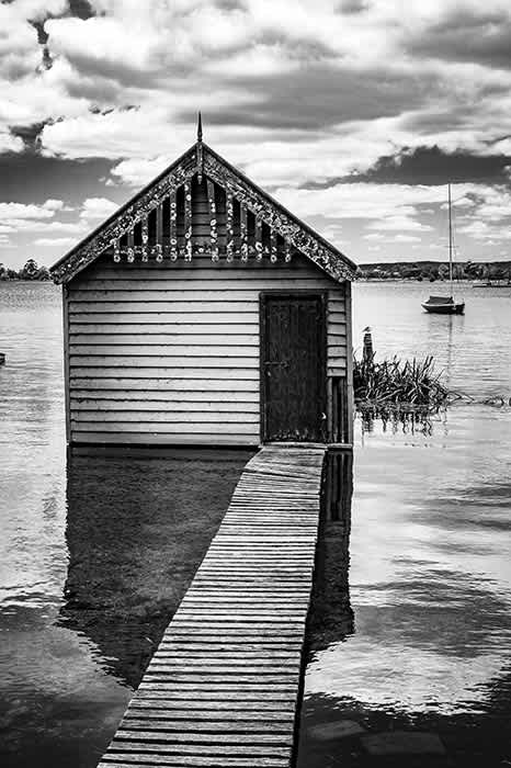 Photograph of an old weathered lake boat house.