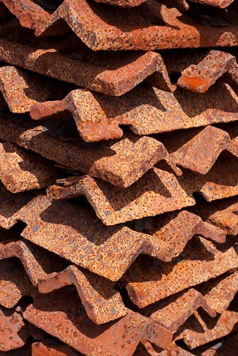 Photograph of rusty stack of angle iron.
