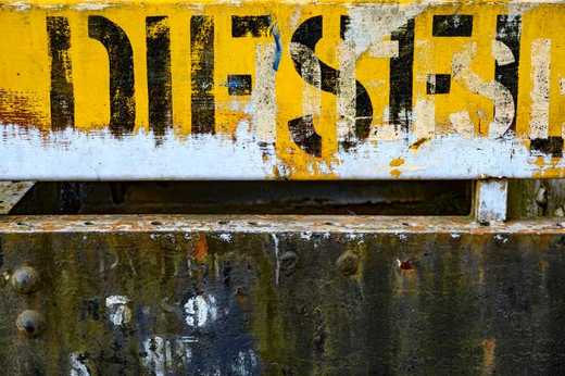 Photograph of 'Diesel' stenciled letters on rusty freight train carriage. 