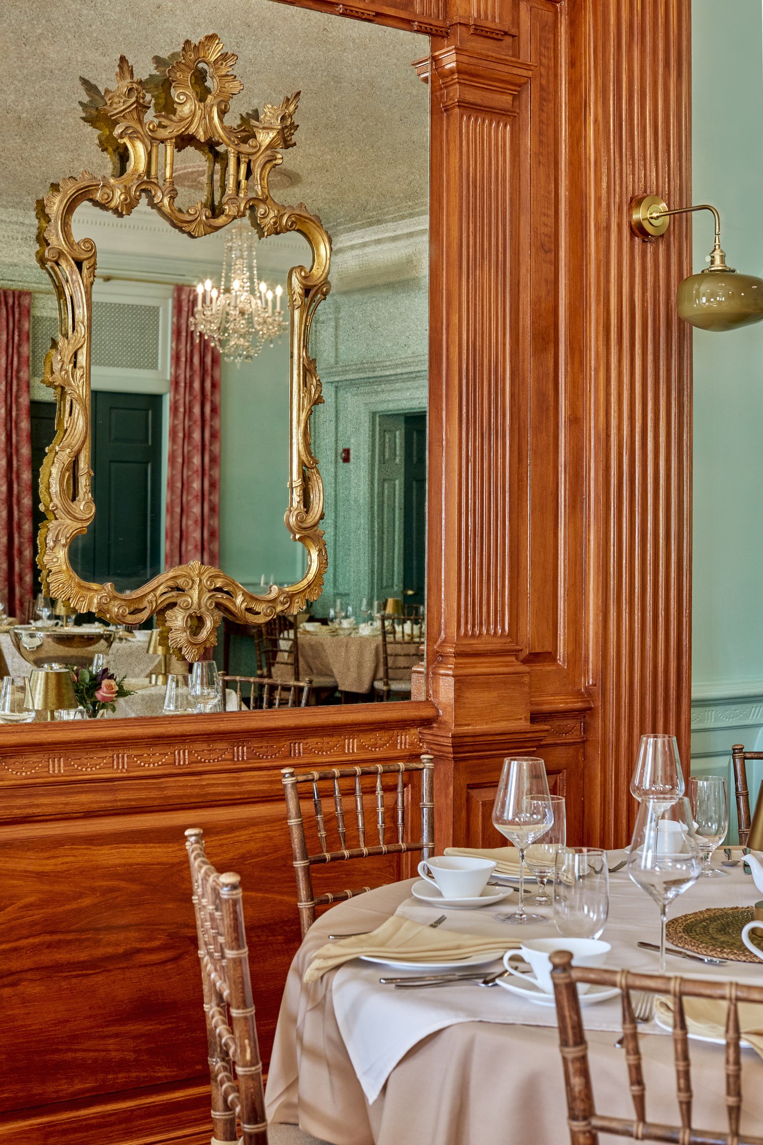 Gradient paint finish on walls. Faux mahogany wood grain finish. Antique mirrored glass. Custom hand blown glass globe for wall sconce.