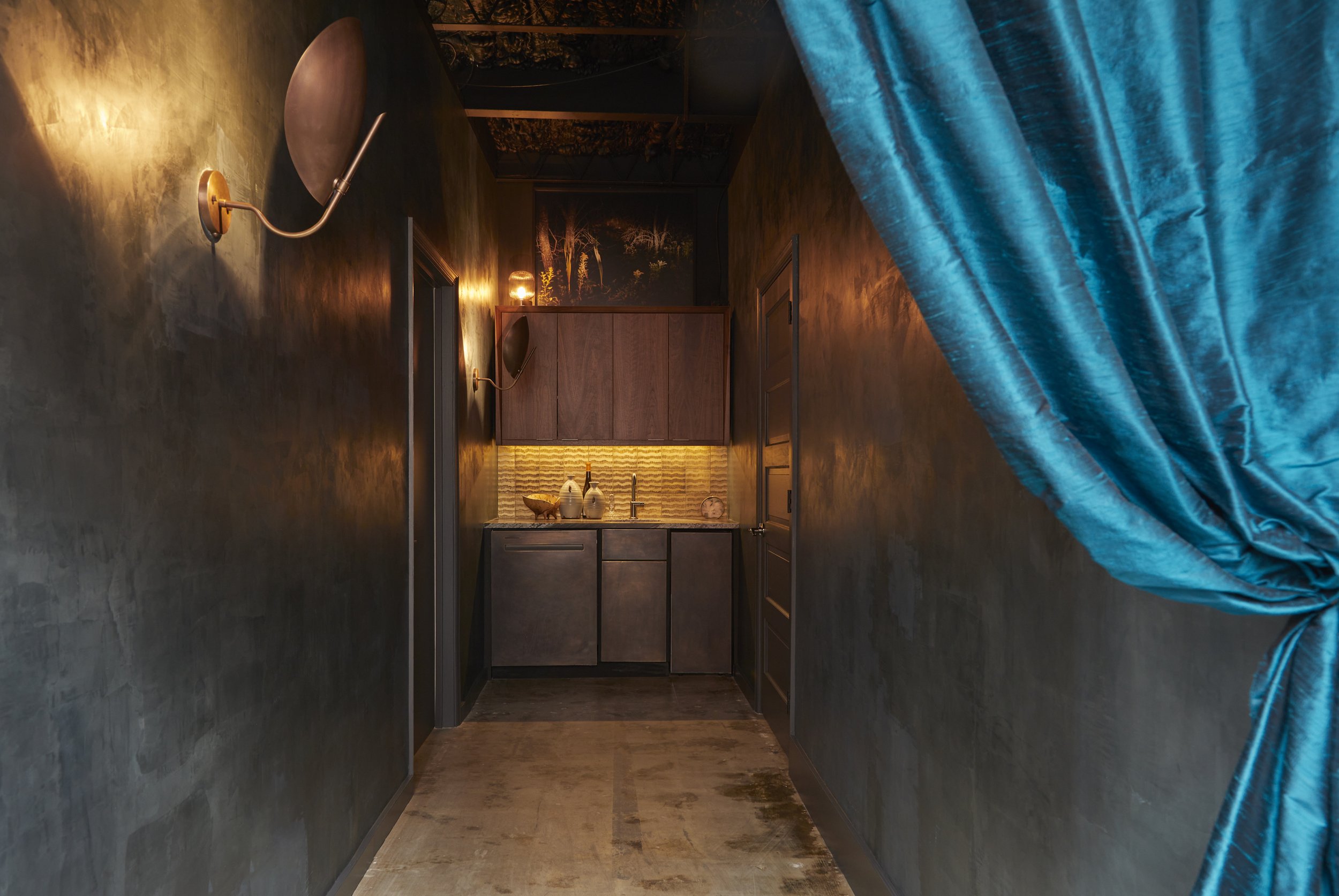 Wet bar. Venetian plastered walls. Brass front lower cabinets. Walnut upper cabinets. Elise Rasmussen photography. Brass beetle wall sconces. Raw silk drapery.