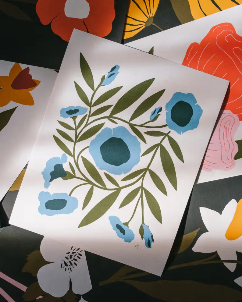 Layered art prints show blue, white, red and yellow flowers.