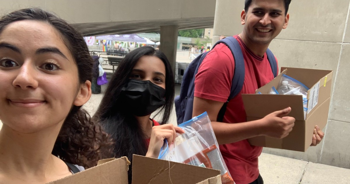 Members of the Blankets for T.O. executive team carry boxes of care packages for donation.