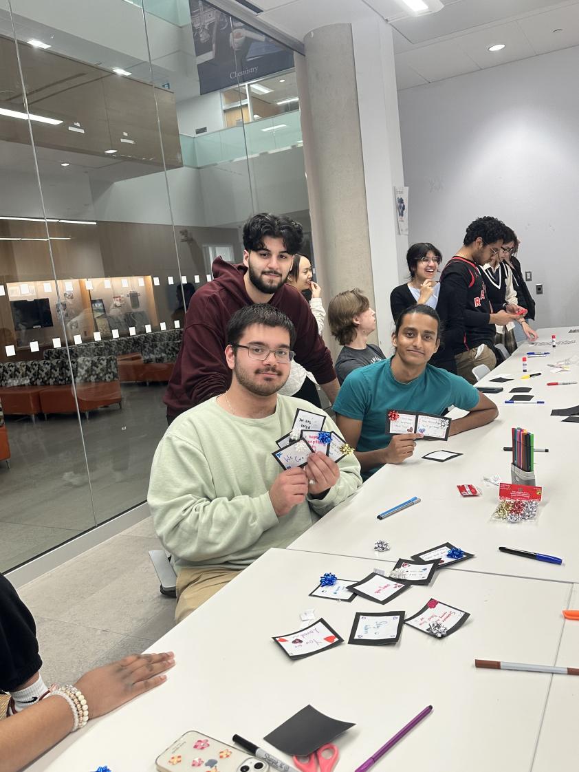 Students hold up some of the cards that they made.