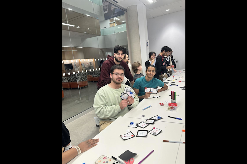 Students hold up some of the cards that they made.