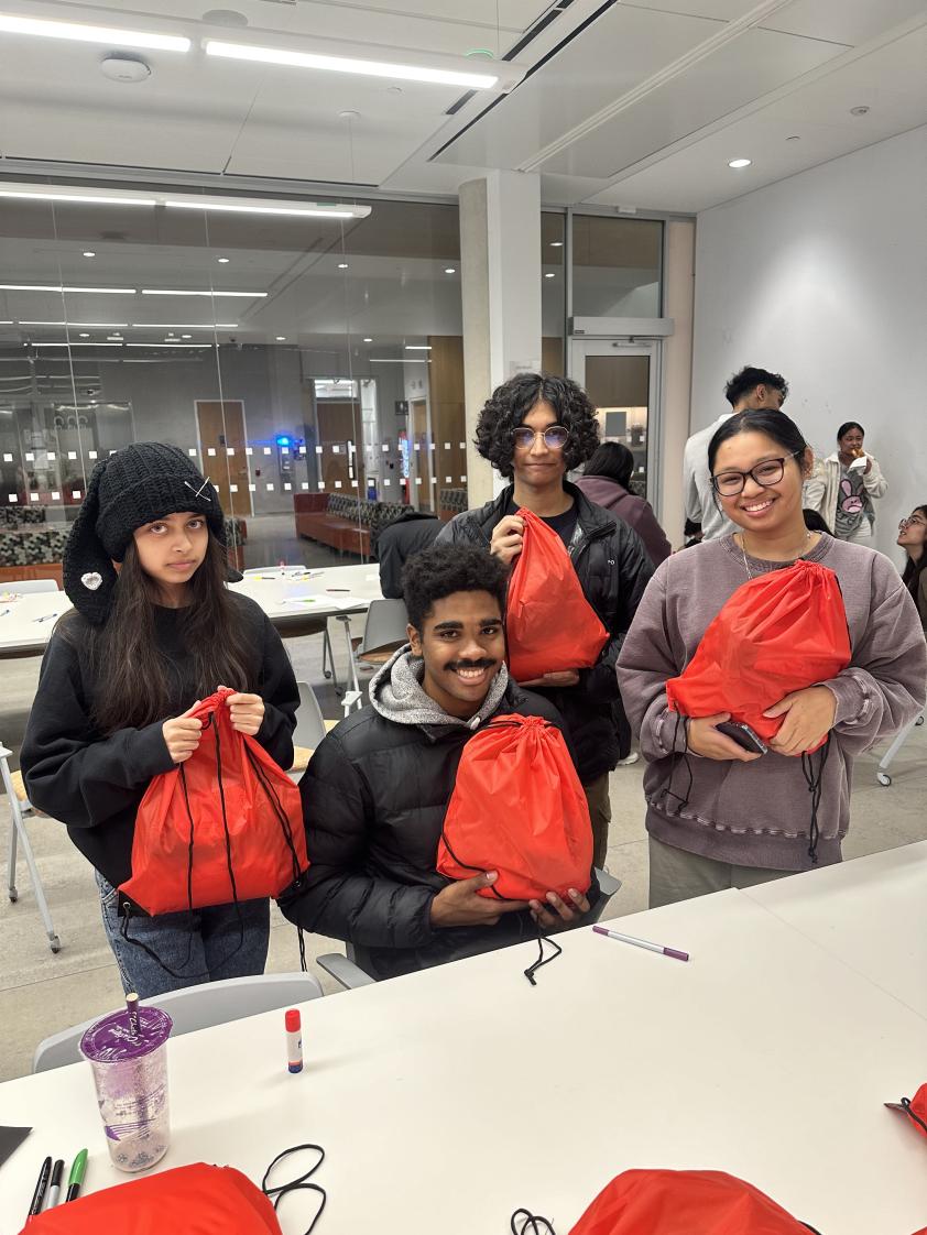 Students hold up the care packages that they packed.