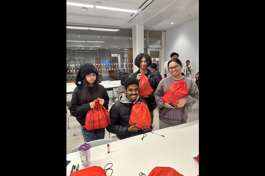 Students hold up the care packages that they packed.