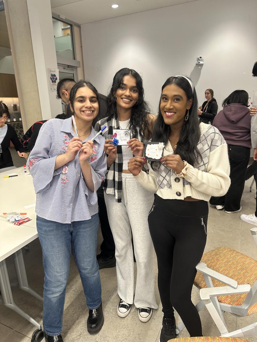 Members hold up some cards made during the event.