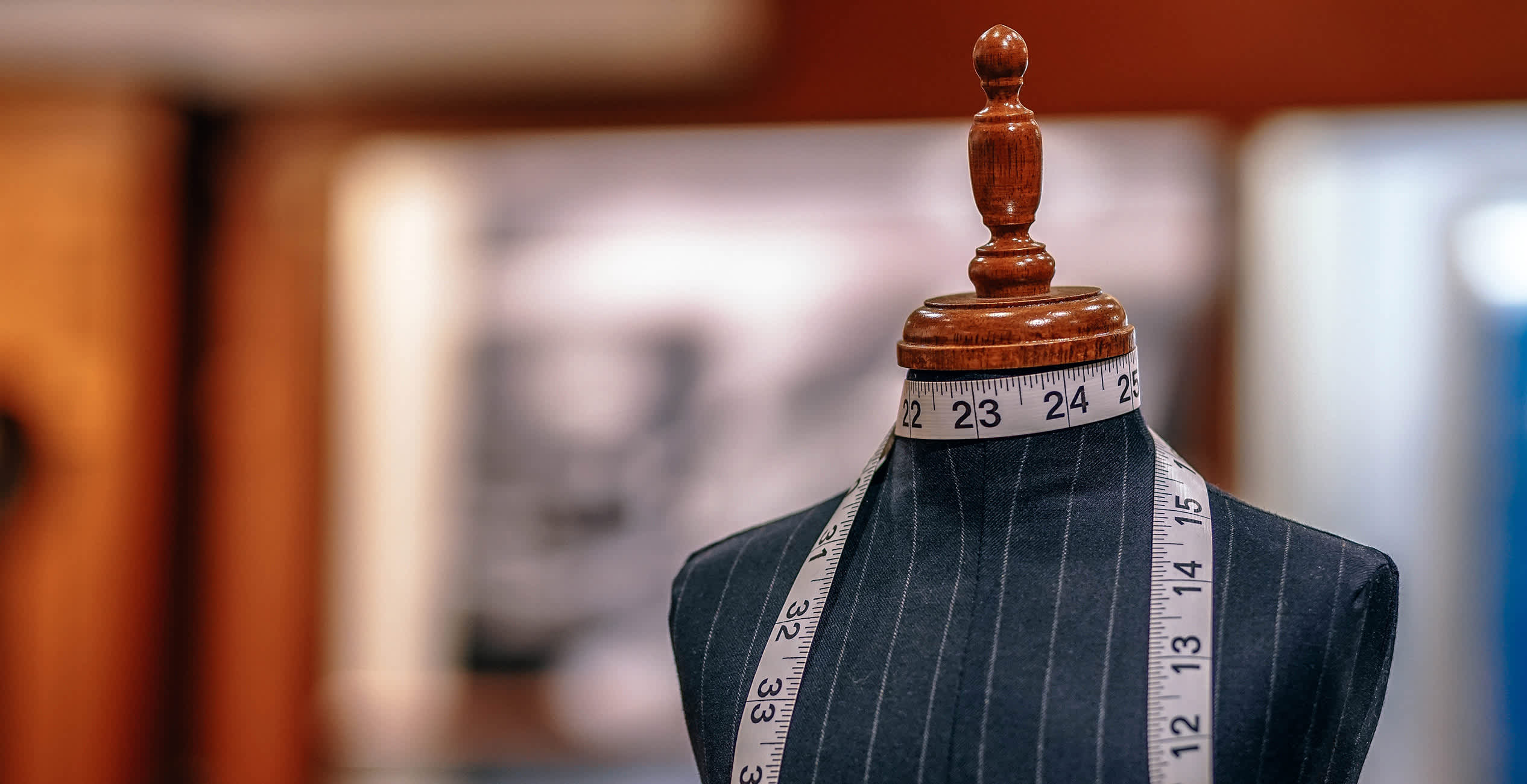 A tailor's form with a tape measure in a store.
