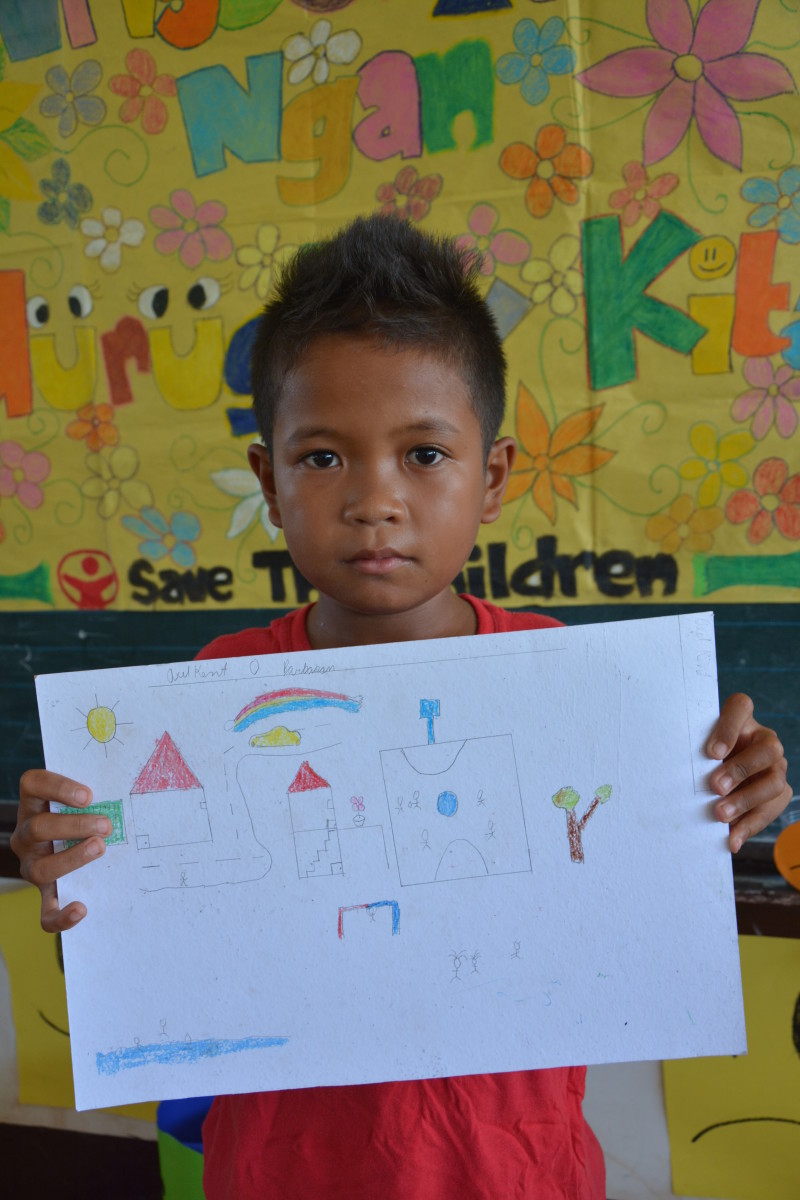 Estudiante filipino con una carta entregada por Save the Children.