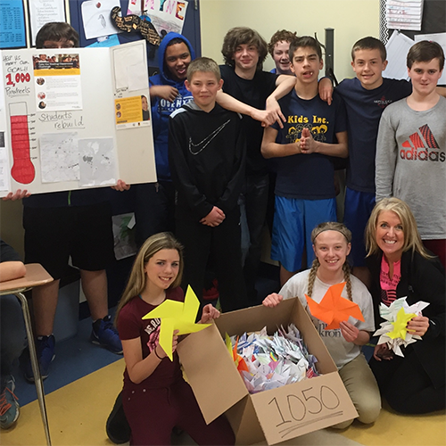 The Caring Comets team with their 1050 pinwheels made for the Healing Classrooms Challenge.