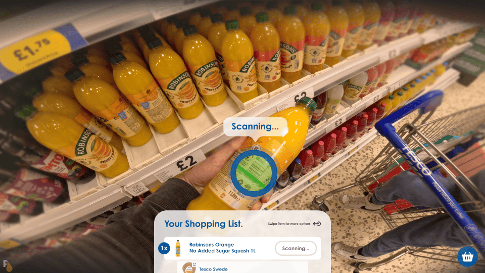 Close-up view of a shopper's hand holding a bottle of Robinsons Orange No Added Sugar Squash in a grocery store, with an augmented reality overlay showing the item being scanned and checked off a shopping list on Apple Vision Pro AR glasses