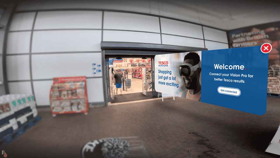 Augmented reality view through Apple Vision Pro AR glasses showing an entrance to a Tesco store with a promotional sign saying 'Shopping just got a lot more exciting' and a welcome screen prompting to connect the Vision Pro for better Tesco results.