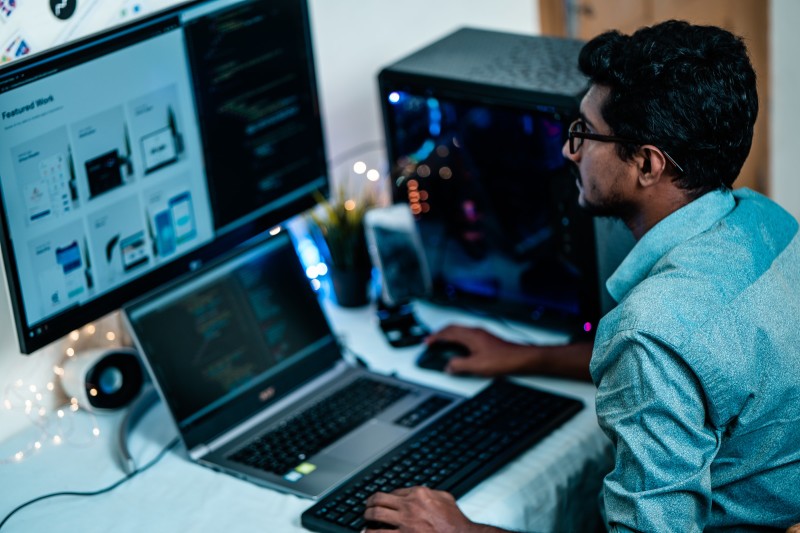 Image of a mat sitting in front of many computer monitors