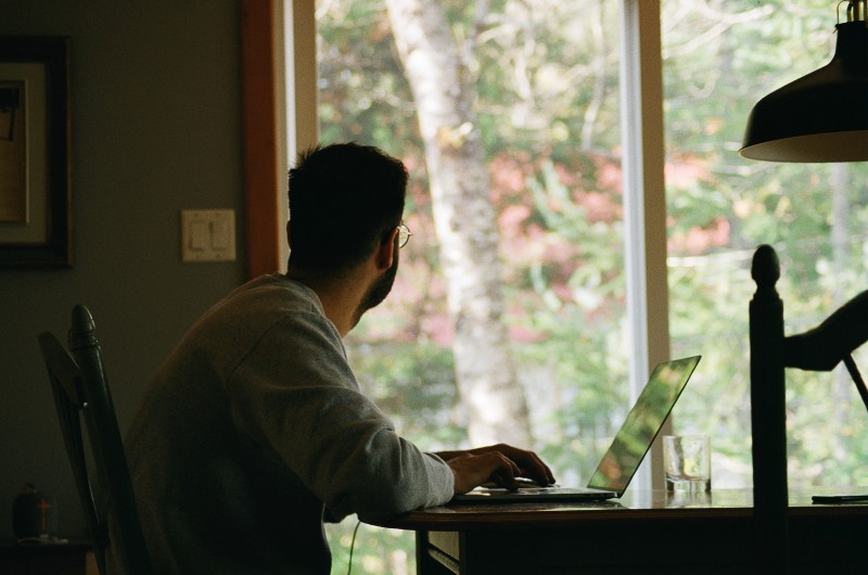 Image of a man sitting at a desk looking outside